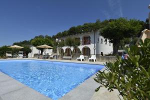 a villa with a swimming pool in front of a building at B&B VILLA GINEVRA in Pietralunga