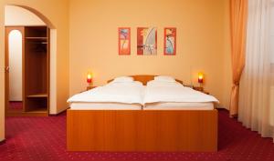 un grande letto in una stanza con due candele di Penzión Kamélia a Žilina