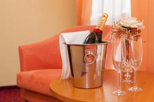 um balde com uma garrafa de champanhe e copos sobre uma mesa em Penzión Kamélia em Žilina