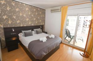 a bedroom with a large bed and a balcony at DIFFERENTFLATS Santa Rosa in Salou