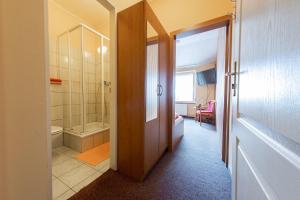 a bathroom with a walk in shower and a toilet at Penzion Školička in Prague