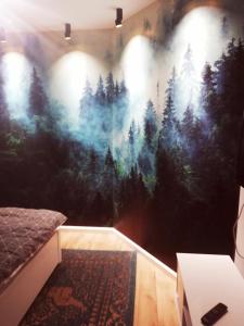 1 dormitorio con un mural de un bosque en Apartamenty przy Gimnazjalnej, en Bydgoszcz