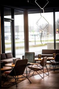 a room with chairs and tables and a large window at ibis Wels in Wels