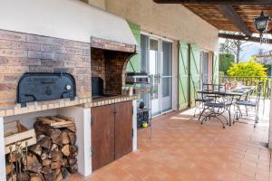 an outdoor patio with a fireplace and a table at Villa Bellet in Nice