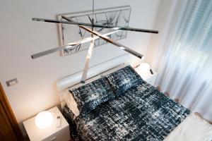 een slaapkamer met een bed met een kroonluchter erboven bij Fly by Suites Pescara in Pescara