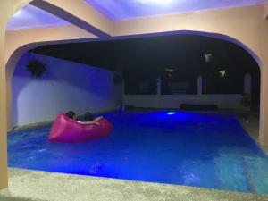 a pool in a house with a red boat in it at Larosa Hostel Bed and Breakfast in Puerto Princesa City