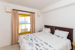 een slaapkamer met een groot bed en een raam bij Santorini - Perissa 32 in Ballito