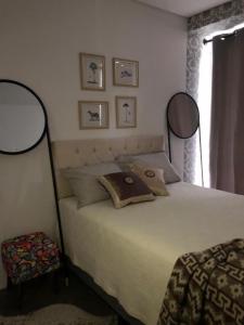 Un dormitorio con una cama con dos espejos. en Gaudi Loft Design 50, en Campos do Jordão