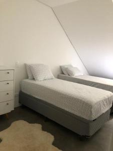 1 dormitorio con 2 camas junto a una cómoda y una cama en Gaudi Loft Design 50, en Campos do Jordão