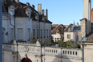 une clôture blanche devant certains bâtiments dans l'établissement Hotel Le Jacquemart, à Dijon