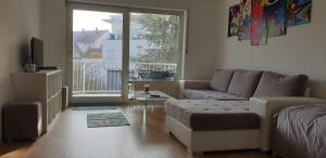 uma sala de estar com um sofá e uma grande janela em KEHL Center Schöne 2 Zimmer Wohnung mit Terrasse 60M2 em Kehl am Rhein