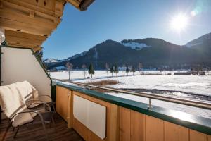 a balcony with a view of a snow covered field at Pension Essbaum in Walchsee