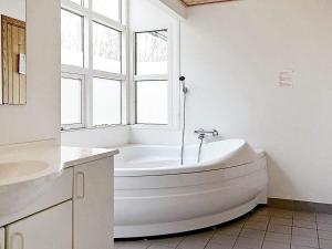 ein weißes Bad mit einer Badewanne und einem Fenster in der Unterkunft Four-Bedroom Holiday home in Hasle 5 in Hasle