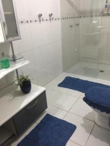 La salle de bains est pourvue d'une douche et de 2 tapis bleus. dans l'établissement GA2-Hospedagem Próximo ao Aeroporto de Guarulhos, à Guarulhos