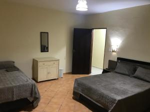 a bedroom with two beds and a dresser and a door at GA2-Hospedagem Próximo ao Aeroporto de Guarulhos in Guarulhos