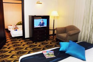 a hotel room with a bed and a television at Mardhiyyah Hotel and Suites in Shah Alam