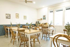 Annie's Bed&Breakfast في زغرب: غرفة طعام مع طاولات وكراسي ونوافذ