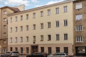 duży budynek z samochodami zaparkowanymi przed nim w obiekcie Vienna City Apartments Krongasse w Wiedniu