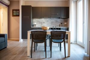 a kitchen with a table and chairs in a room at Appartamenti Villa Gloria in Peschiera del Garda