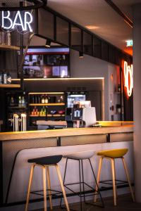 un bar con due sgabelli di fronte a un bancone di ibis Wels a Wels Altre 37 foto