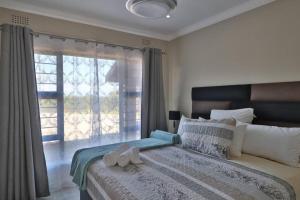 a bedroom with a large bed with a window at C-More on Churchill in Shelly Beach