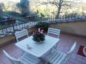 una mesa blanca y sillas con flores en el patio en Il Pettirosso, en Cesano