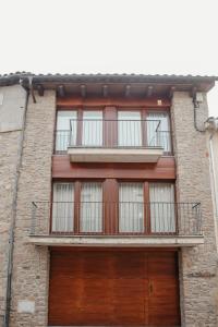 an apartment building with a balcony and two doors at Cal Miquel in Alpens