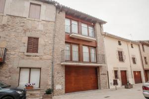 an old stone house with a wooden garage at Cal Miquel in Alpens