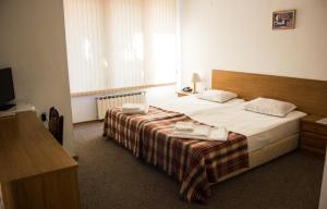 a bedroom with a bed and a television in it at Family Hotel Saint Iliya in Burgas City +52 photos