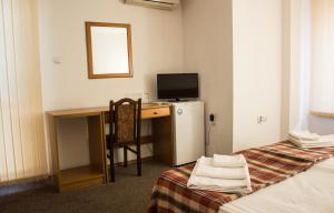 a hotel room with a desk and a television at Family Hotel Saint Iliya in Burgas City