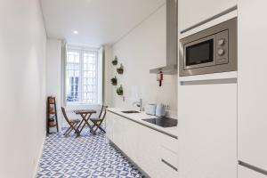 kuchnia z białymi szafkami oraz niebiesko-białą podłogą w obiekcie FLH Downtown Aqua Apartment w Lizbonie