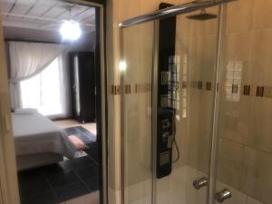 une salle de bain avec douche et une chambre avec un lit dans l'établissement Ankuweni Guest house, à Giyani