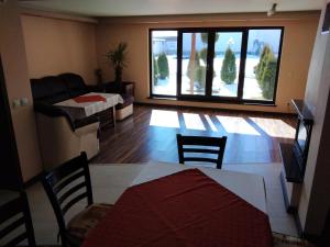 a living room with a table and chairs and a couch at Sveti Nikola Villas near Borovets in Shiroki Dol +106 photos