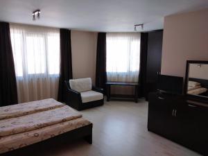 1 dormitorio con cama, silla y espejo en Sveti Nikola Villas near Borovets en Shiroki Dol