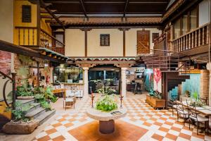 uma grande sala com mesas e vasos de plantas em Hotel Spa La Casa del Rector Almagro em Almagro
