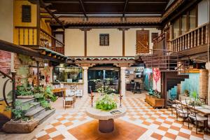 a large room with tables and potted plants in it at Hotel Spa La Casa del Rector Almagro in Almagro