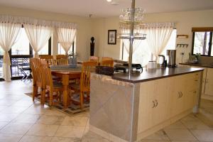a kitchen and dining room with a table and chairs at Baobab - NUDE - SunEden Family Naturist Resort in Pretoria