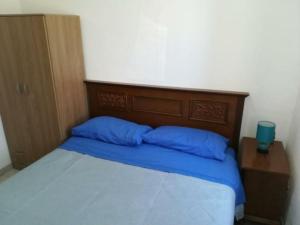 un letto con due cuscini blu sopra di Casa vacanze Sardegna (Viddalba) a Viddalba