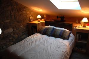 - une chambre avec un lit et 2 tables avec des lampes dans l'établissement Gîte La Grange, à Bielle