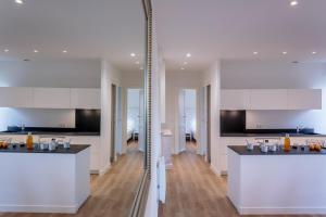 a kitchen with white cabinets and black counter tops at IZOKINA KEYWEEK 2 bedroom Apartment in Biarritz in Biarritz +13 photos