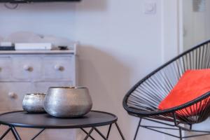 two metal bowls sitting on a table next to a chair at IZOKINA KEYWEEK 2 bedroom Apartment in Biarritz in Biarritz