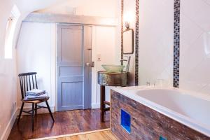 a bathroom with a tub and a chair and a sink at Domaine de Planchoury in Saint-Michel-sur-Loire