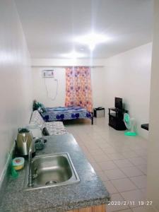 eine Küche mit einem Waschbecken und ein Wohnzimmer in der Unterkunft Urban Deca Tondo Manila by Gracey's Place Unit 3 in Manila