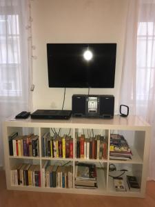 a white book shelf with a tv on top of it at The Barts City Center - Self Check-in in Vienna
