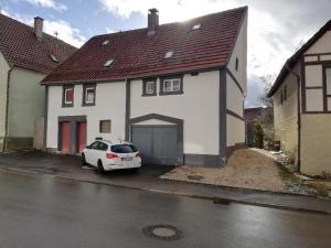 una macchina bianca parcheggiata di fronte a una casa bianca di LMI Haus & Urlaub Monteurwohnungen 2 a Münsingen
