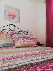 ein Schlafzimmer mit einem Bett mit einer bunten Bettdecke in der Unterkunft Apartamento Naturista en primera línea en Natura World! in Vera