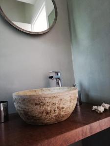 a bathroom with a stone sink with a mirror at Aloni Studios and Apartments in Lassi