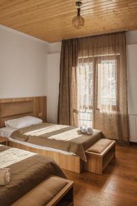Hotel panorama svaneti في ميستيا: غرفة نوم بسريرين ونافذة