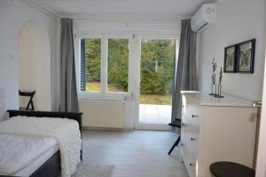 a bedroom with a bed and a large window at Apartments Villa AnnaMaria in Bled