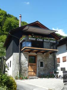 a small house with a balcony and a wooden door at La Petite Grange in Villars-sur-Ollon